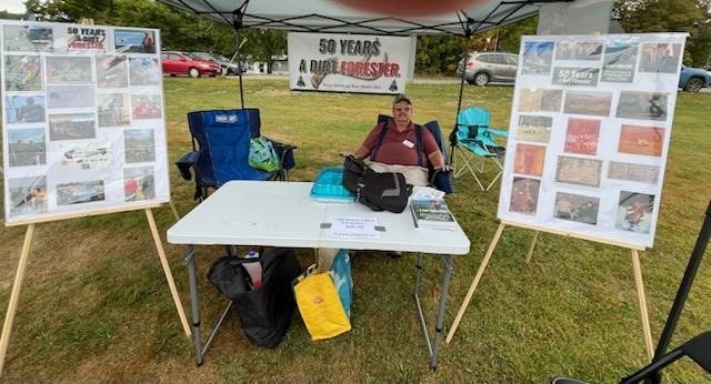 A display table of photographs and clippings at an outdoor event