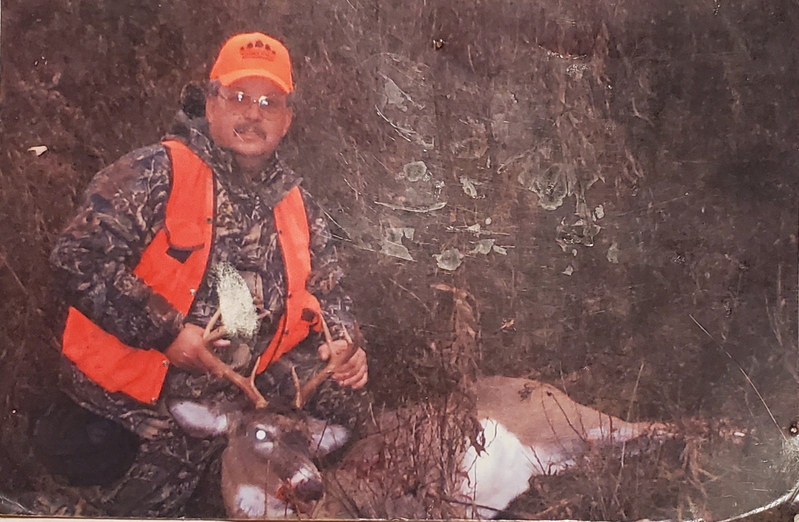 An older photograph from deer season, the hunter in blaze orange