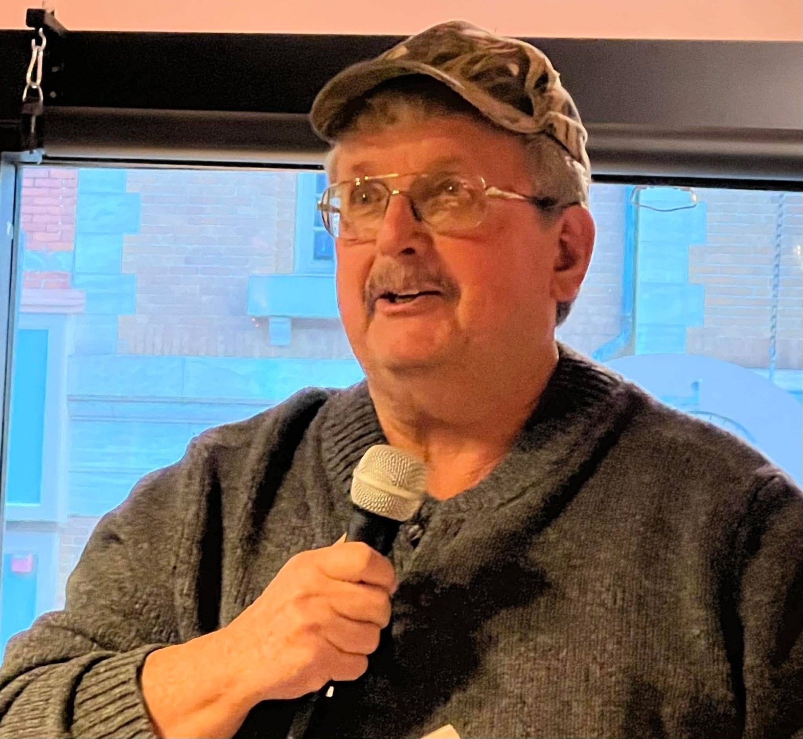 William Sargent speaking with a microphone at an event